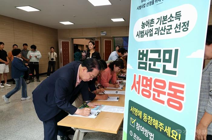 괴산군, 농어촌기본소득 선정 기원 범군민 서명운동, 지난 15일 송인헌 군수가 서명부스를 찾아 1호 서명을 하고 있다.jpg